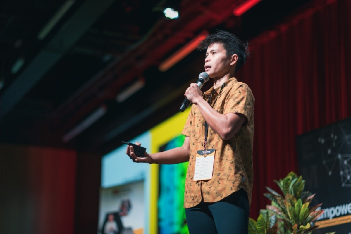 Mickey Mancenido standing with a microphone.