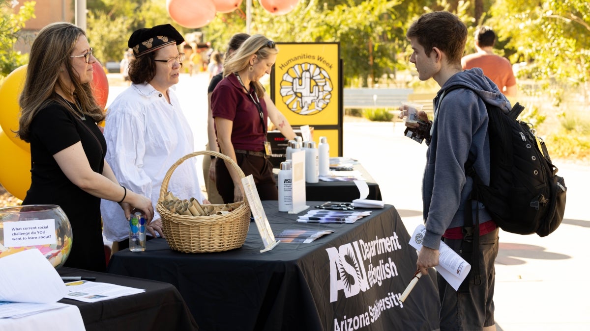 Student looking at table during the Humanities Week Open House.