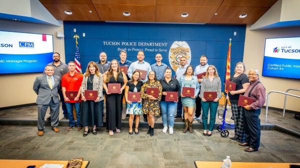 Group of people posing with certificates in their hands.