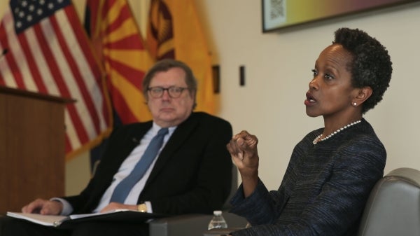 Esther Brimmer talks to an unseen audience, with David Scheffer out of focus sitting next to her