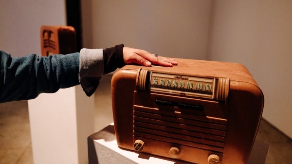 Hand touching the top of a vintage radio