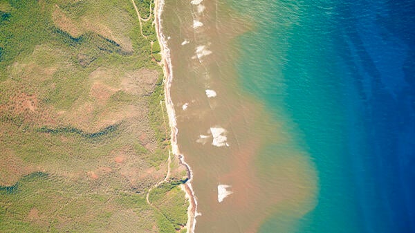 Aerial view of plumes of turbid water on a beach in Molokai, Hawaiʻi.