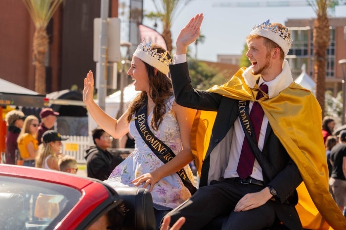Grace Reiter wearing a crown and waving from a float in the 2023 ASU Homecoming parade.
