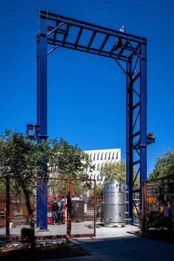 A gantry or large metal arch stands over the base of a cylinder that houses the MechanicalTree